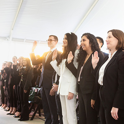 group of law school students raising their hand for the swearing in ceremony